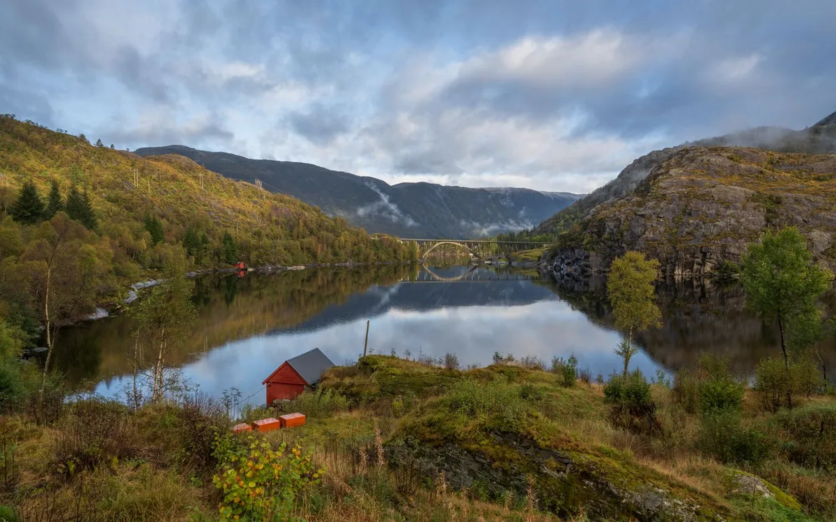 Jakość życia blisko norweskiej natury Drewniany dom nad spokojnym norweskim fiordem