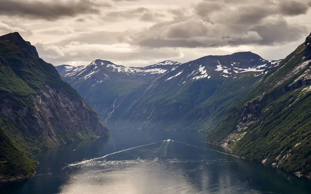 Rejs widokowy po norweskim fiordzie Statek wycieczkowy płynie przez malowniczy norweski fiord