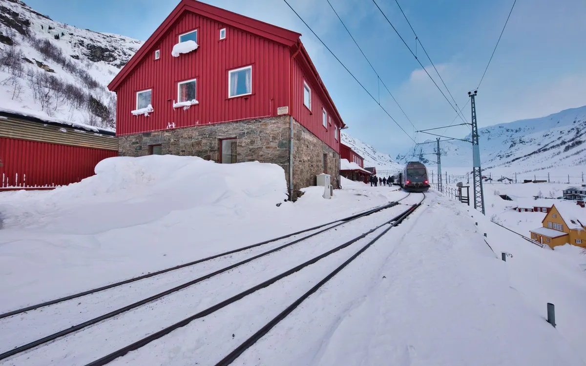 Pociąg jadący przez górską dolinę Norwegii